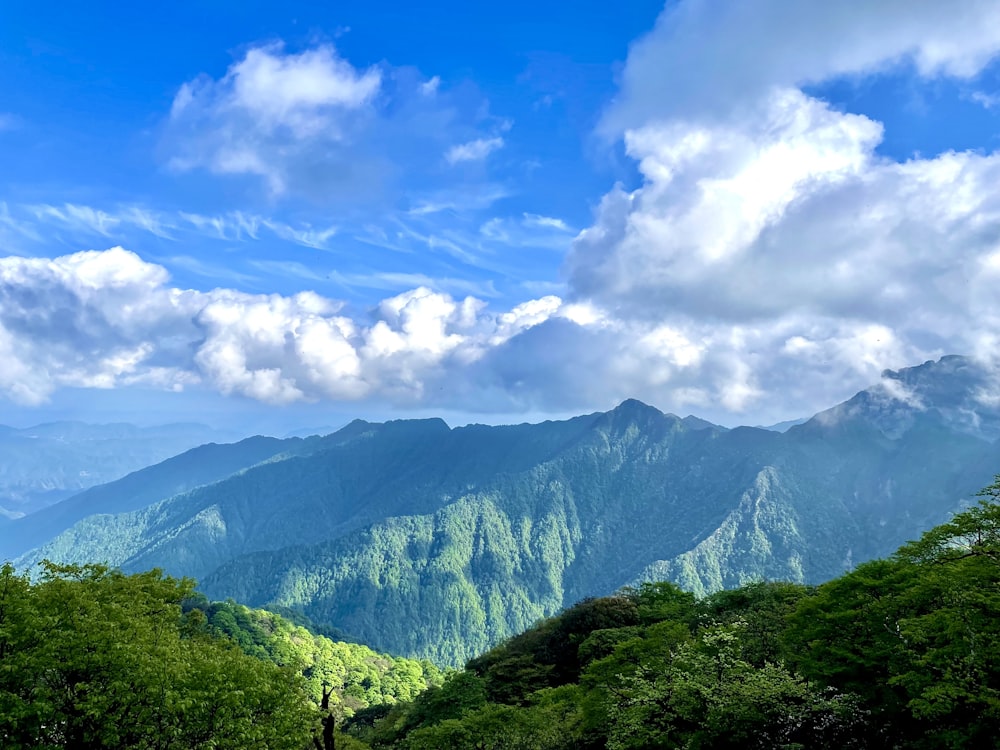 green mountains under white clouds and blue sky during daytime