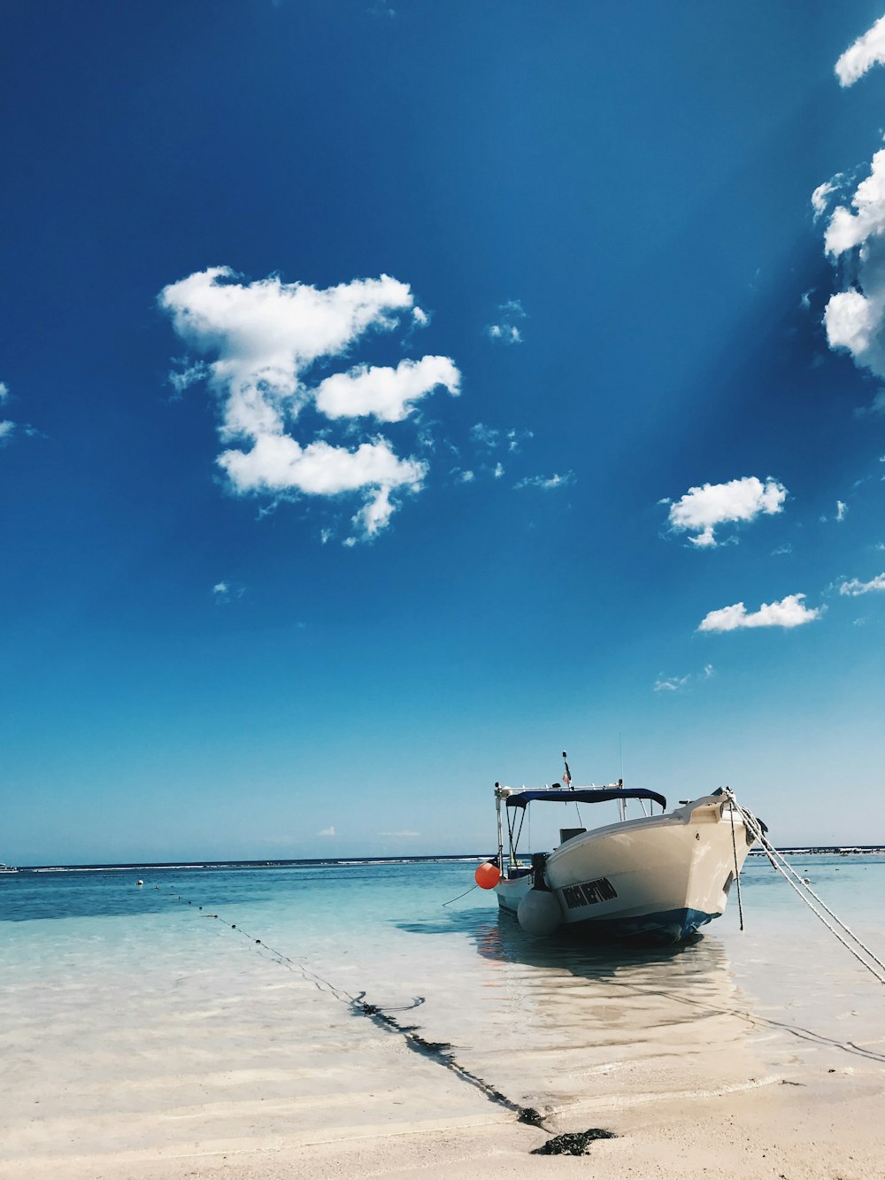 white boat on sea under blue sky during daytime