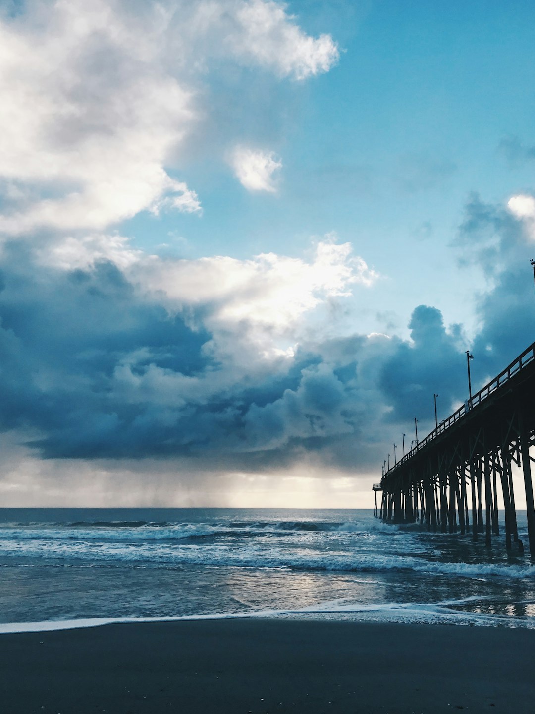 sea dock under blue sky and white clouds during daytime