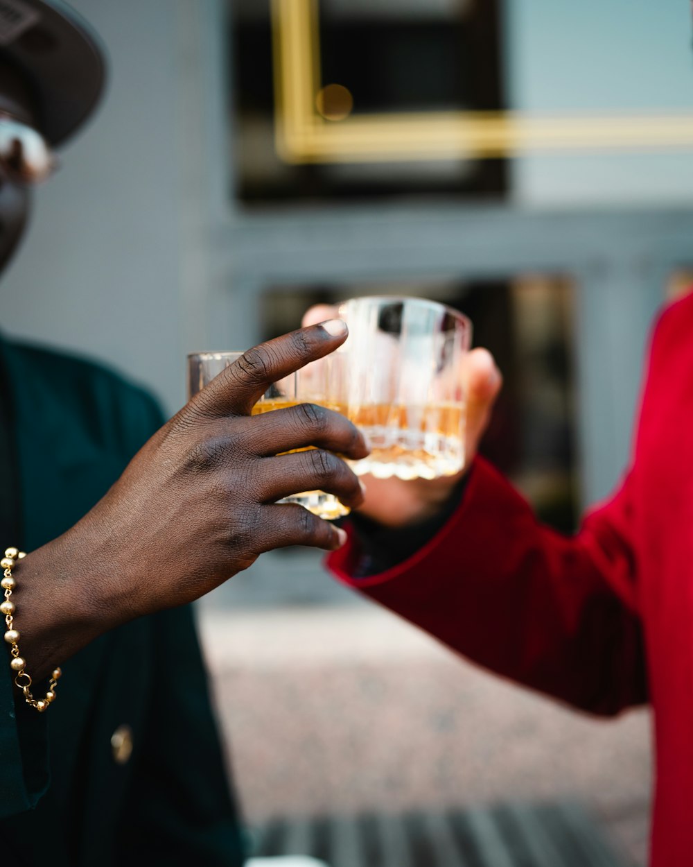 Personne en chemise rouge à manches longues tenant un verre à boire transparent