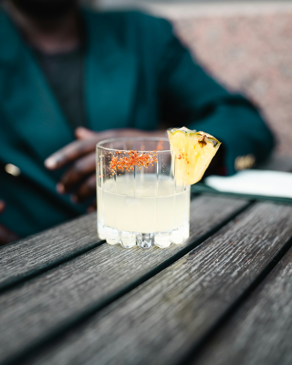 clear drinking glass with yellow liquid on brown wooden table