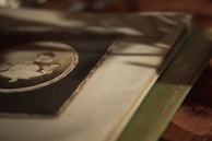 Close-up of hands holding an old photo album filled with colorful pictures.