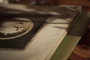A cozy vintage photo album open on a wooden table, surrounded by old family photographs and handwritten notes.