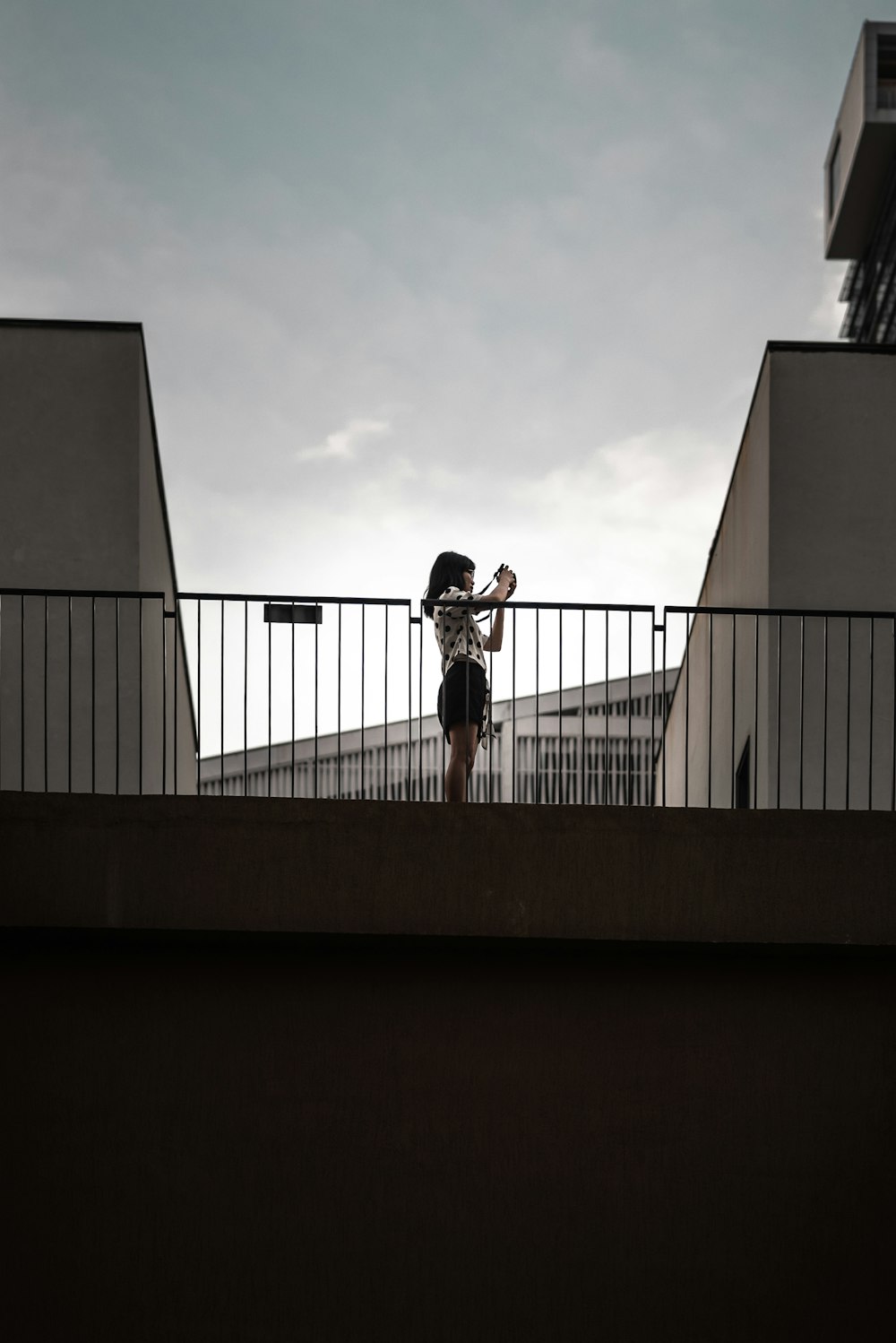 man in black t-shirt and black shorts standing on balcony during daytime