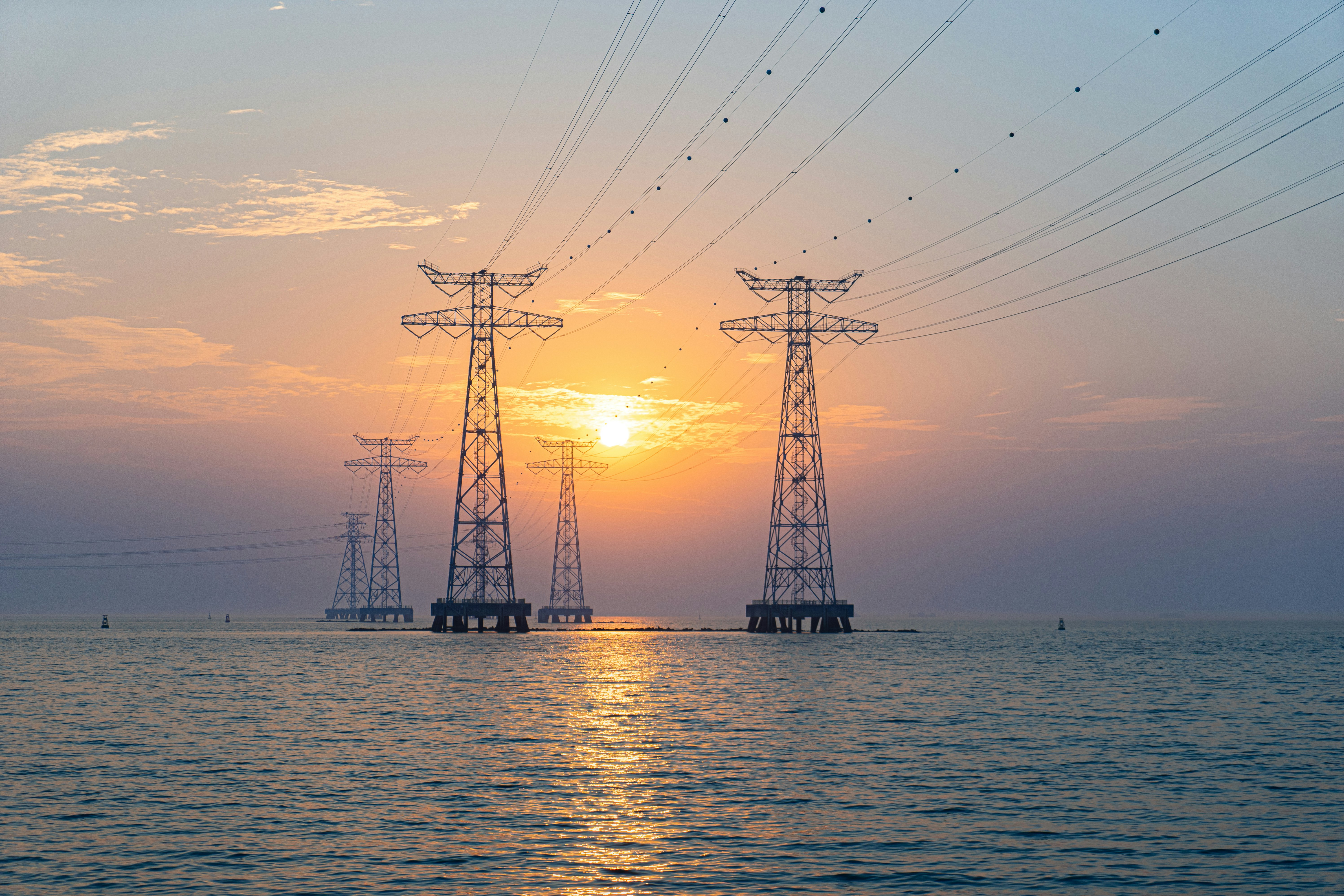 silhouette of wind turbines on sea during sunset