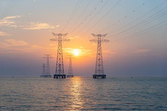 silhouette of wind turbines on sea during sunset