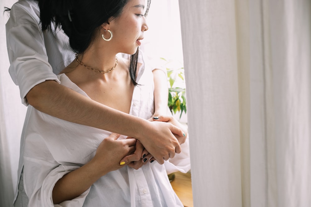 woman in white dress holding her stomach