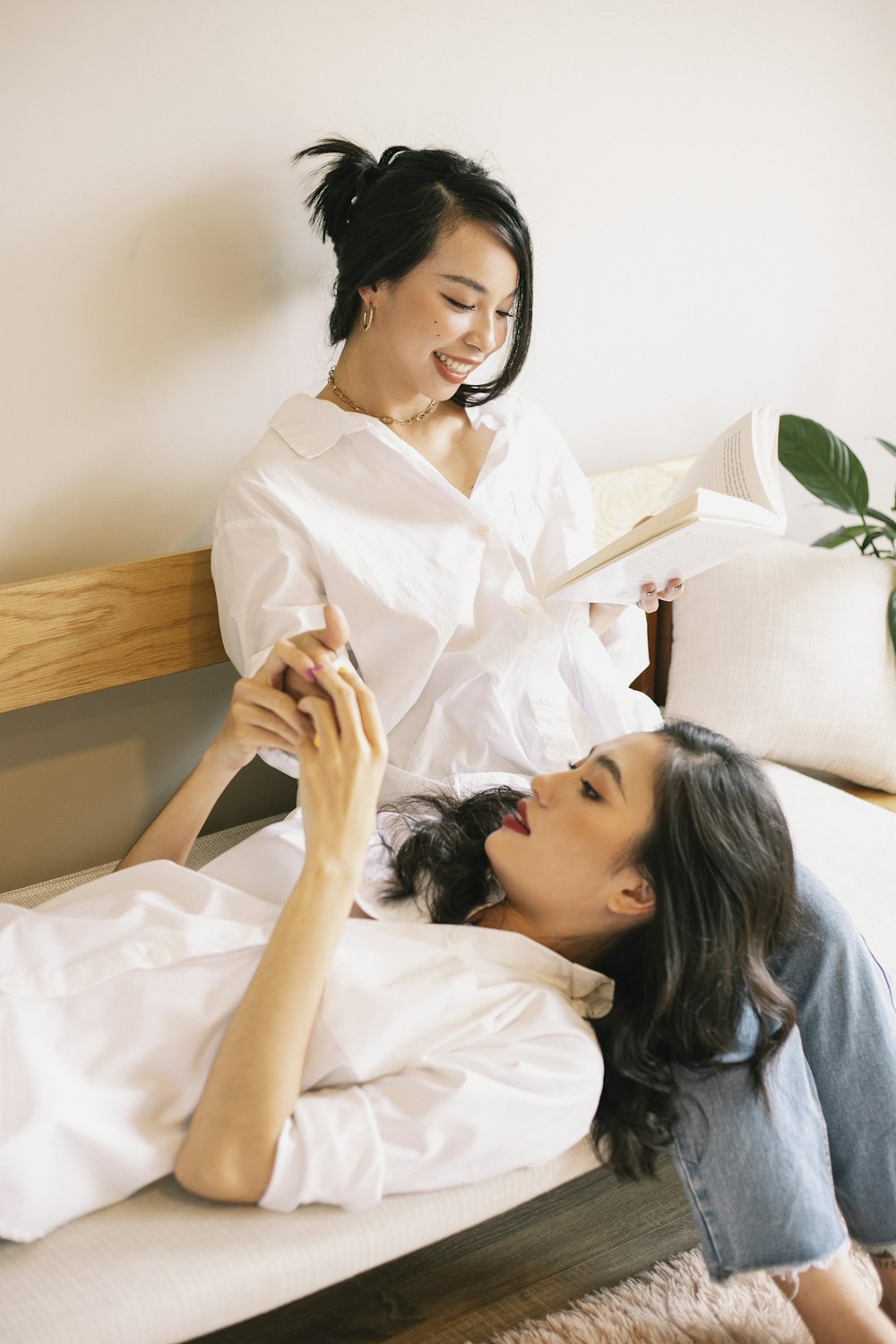 woman in white button up shirt lying on bed