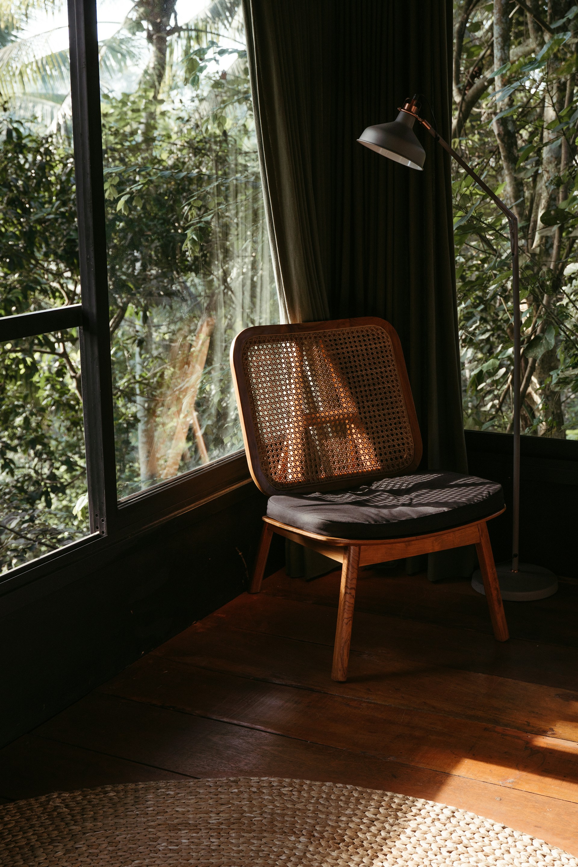 A cozy reading corner bathed in soft natural light, featuring a woven rattan chair with a cream throw and a small wooden side table adorned with a potted succulent.
