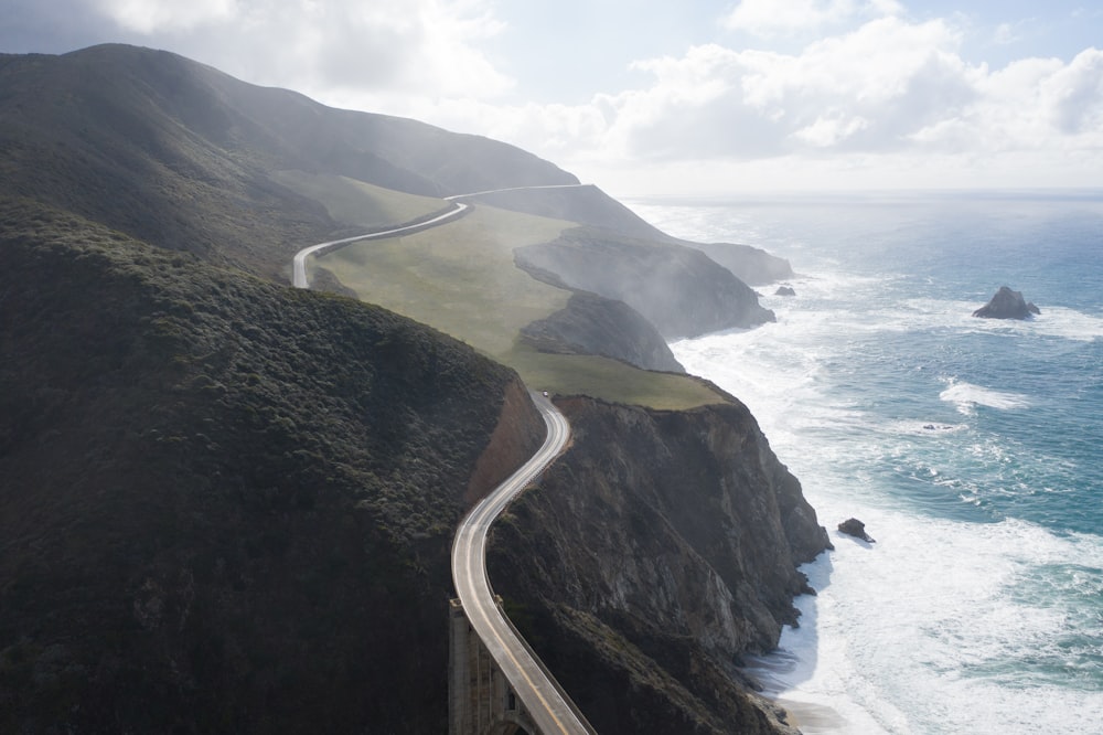 aerial view of road near body of water during daytime