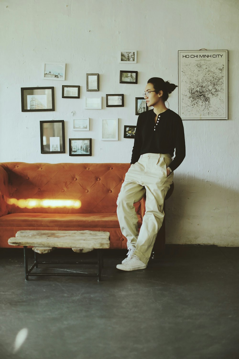man in black long sleeve shirt and white pants sitting on orange bed