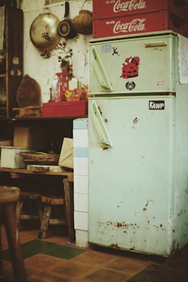 A vintage refrigerator being carefully inspected and cleaned by an experienced technician.