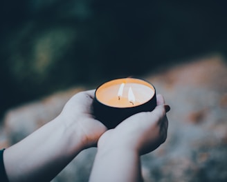 person holding black and orange round ornament