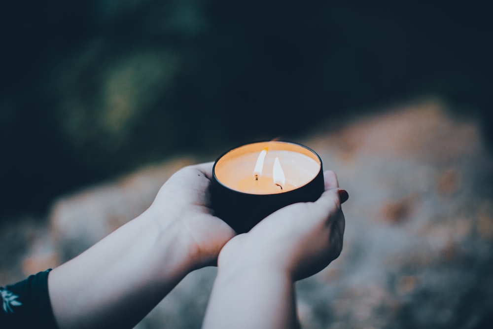 person holding black and orange round ornament