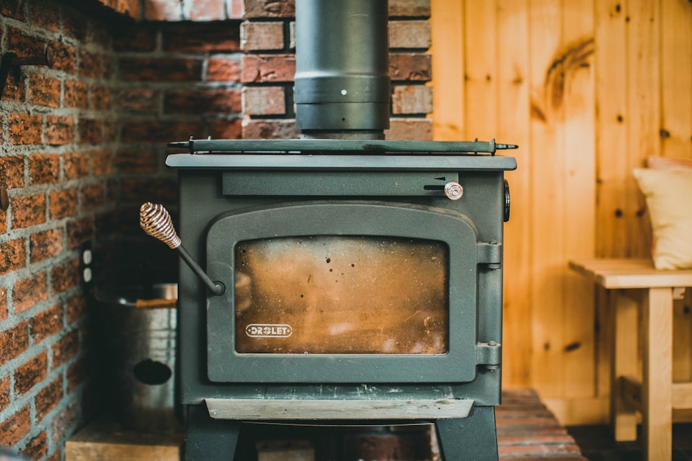 black wood burner near brown brick wall