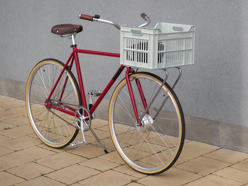 red and white city bike parked beside white plastic crate