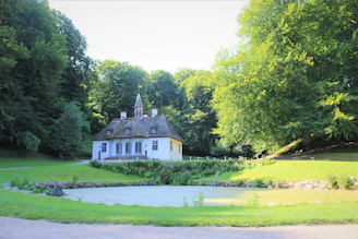 white and brown house near green trees during daytime