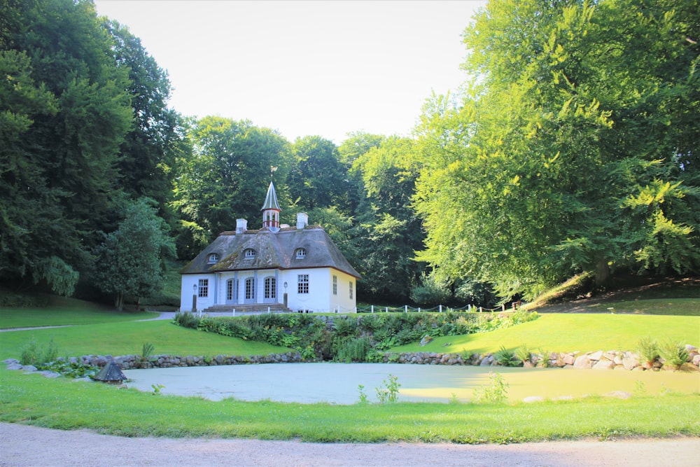 weißes und braunes Haus in der Nähe von grünen Bäumen während des Tages