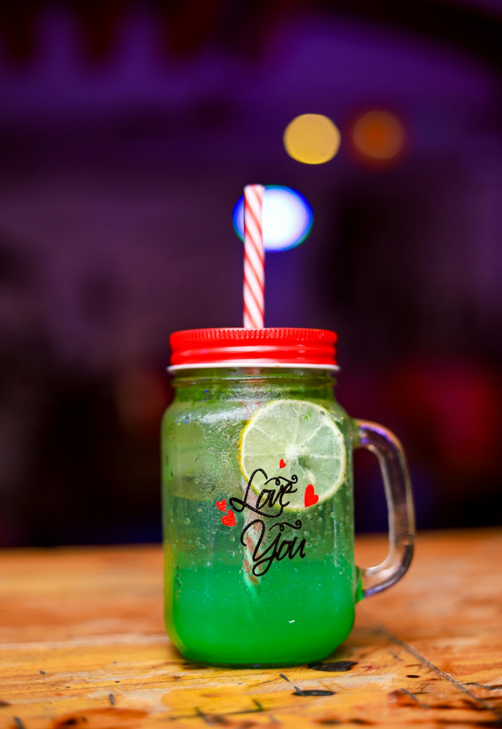 green glass mason jar with red and white straw