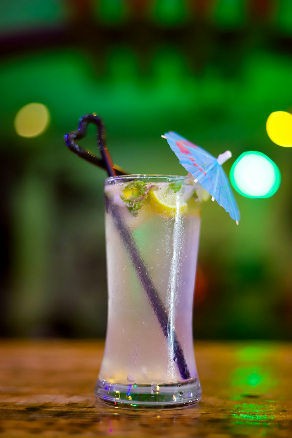 clear drinking glass with white and green straw