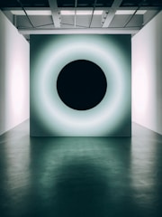 A stylish black and white alarm panel glowing softly in a dim room.