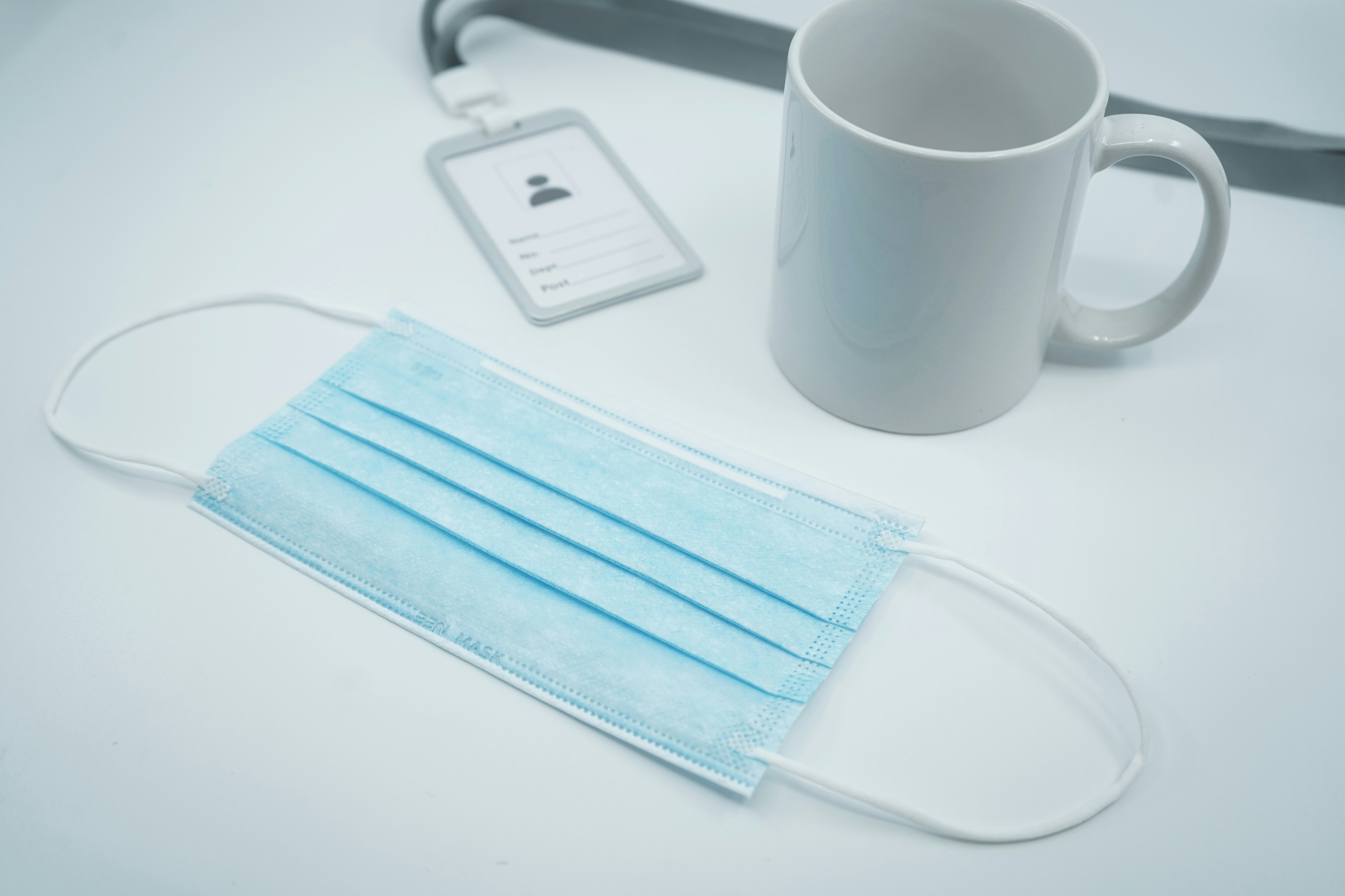 white ceramic mug beside blue book