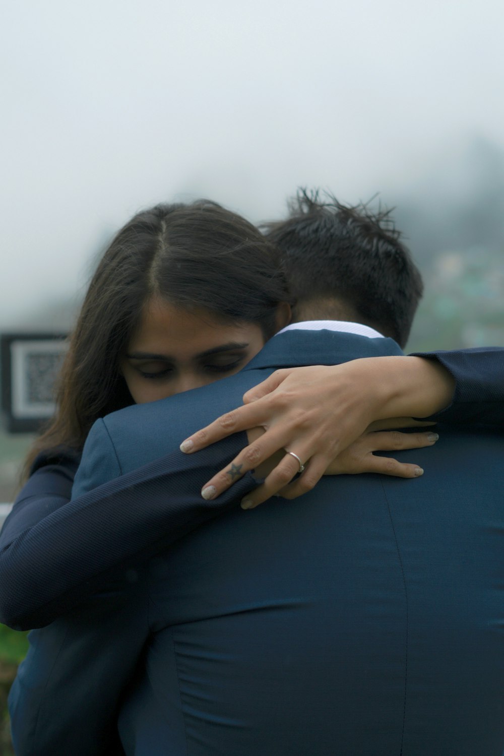 man in black suit hugging woman in black long sleeve shirt