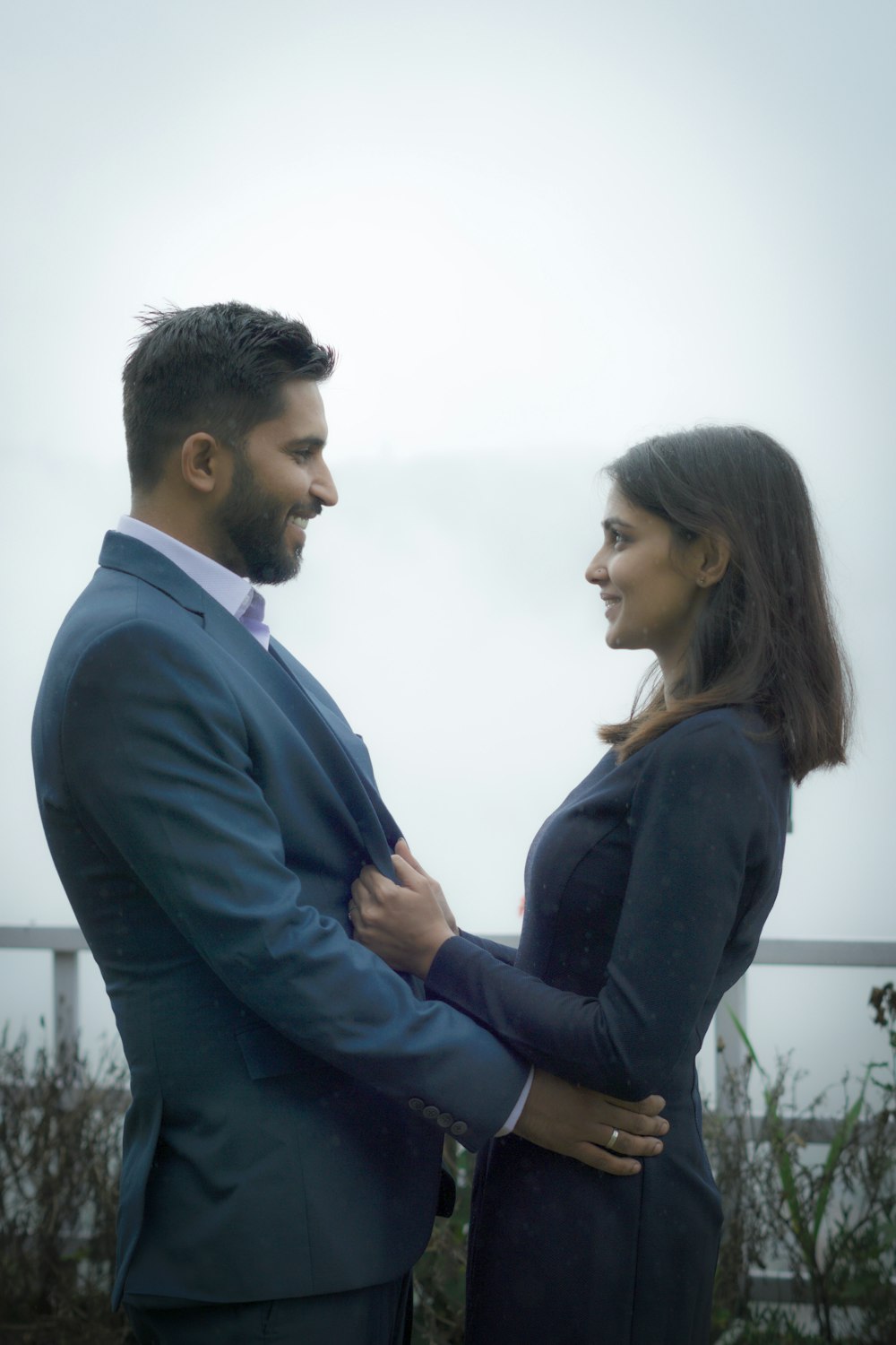 man in black suit jacket kissing woman in blue long sleeve shirt