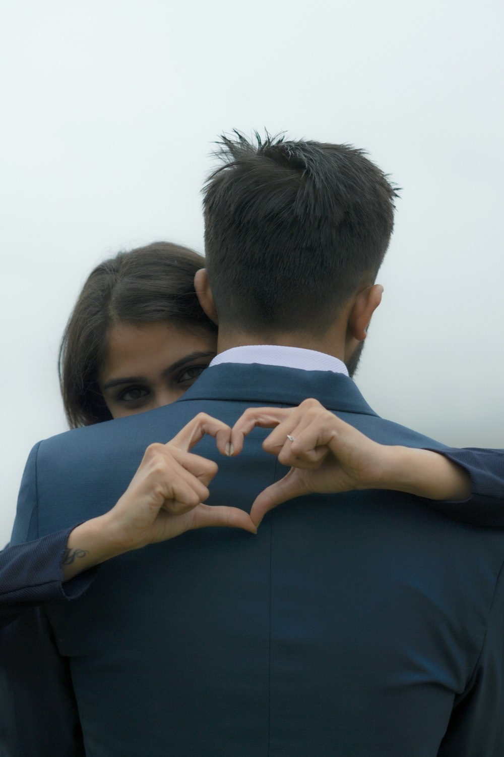 man in black long sleeve shirt hugging woman in blue long sleeve shirt