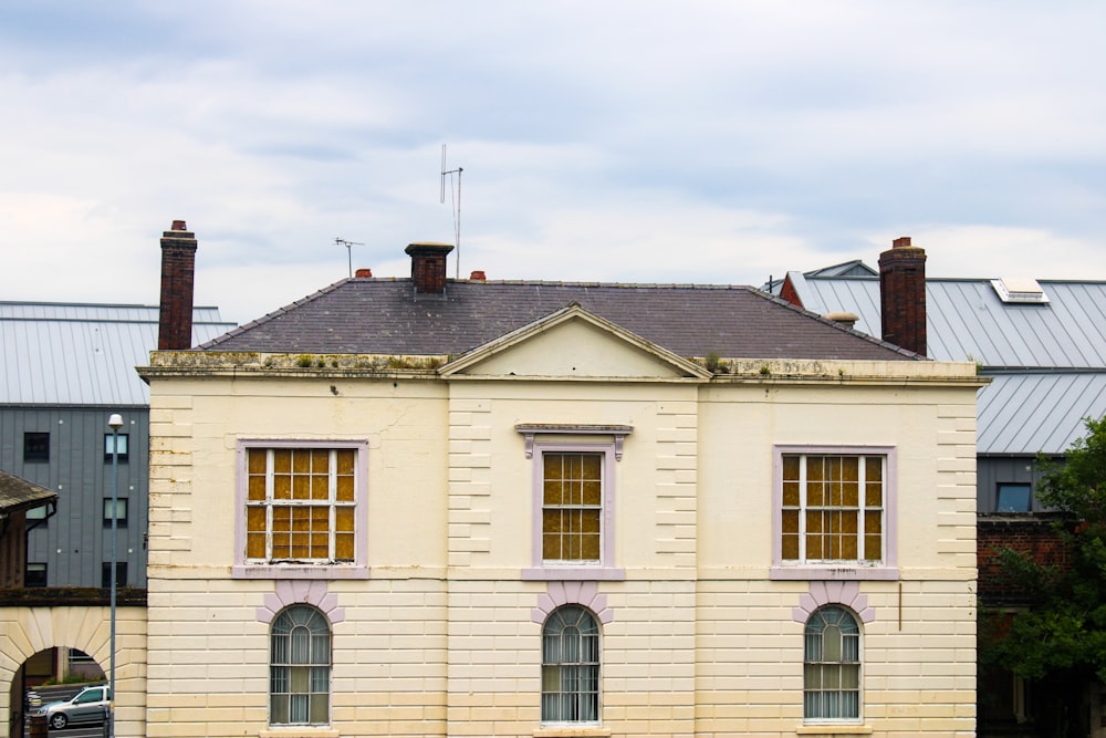 Weißes und braunes Betonhaus unter weißem Himmel tagsüber