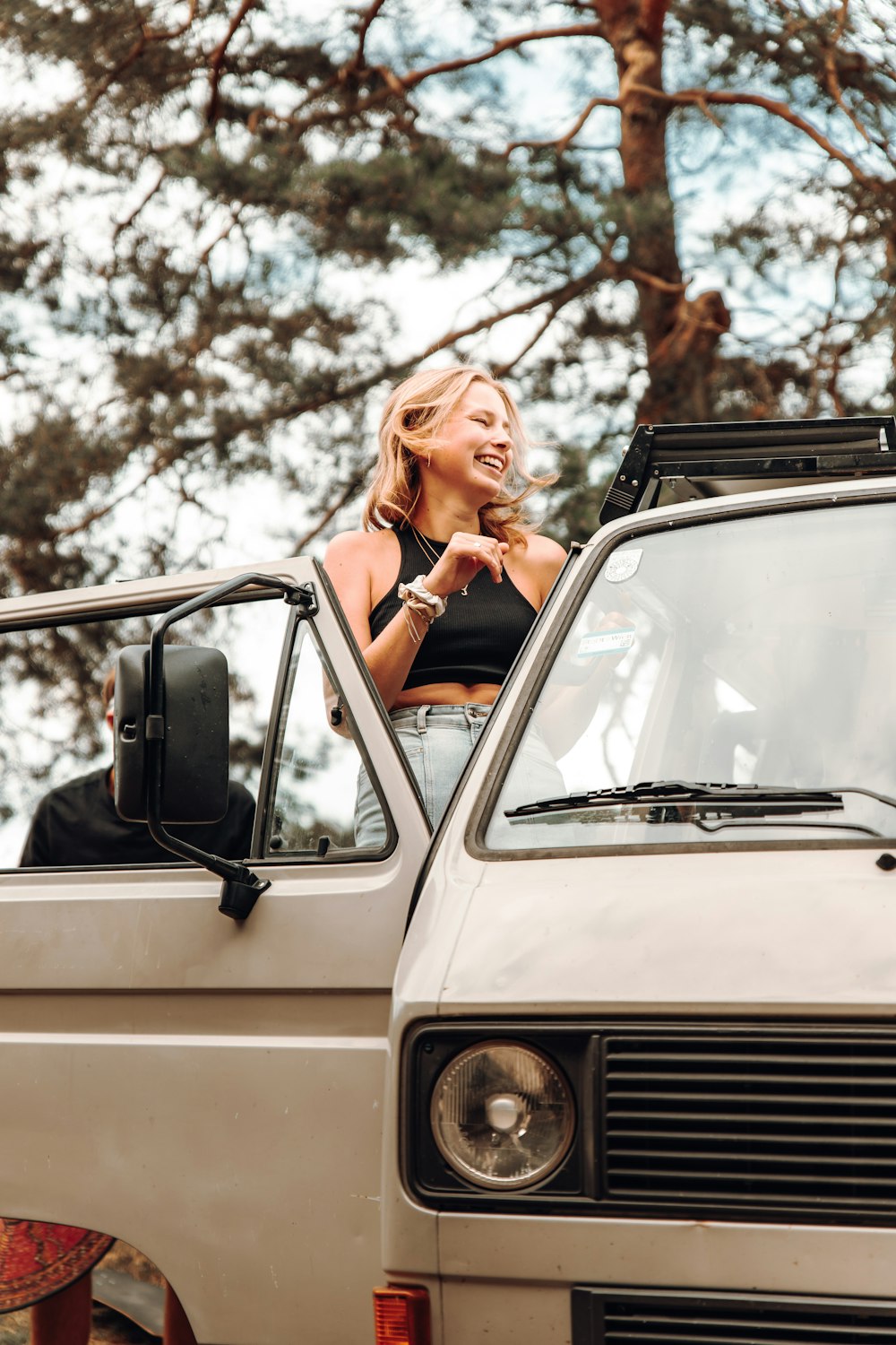 woman in black long sleeve shirt sitting on white car