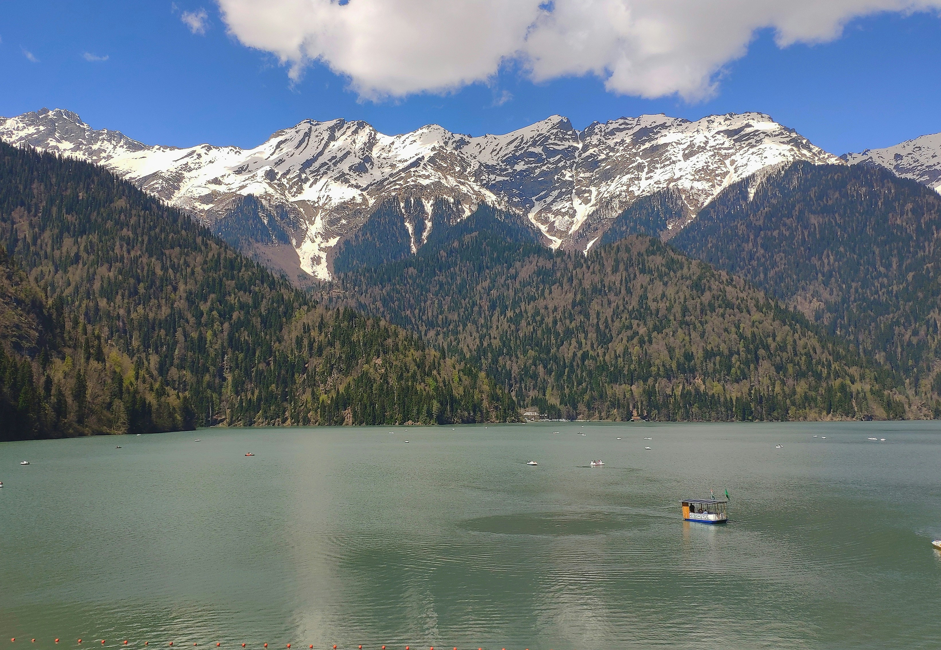 boat on water near snow covered mountain during daytime