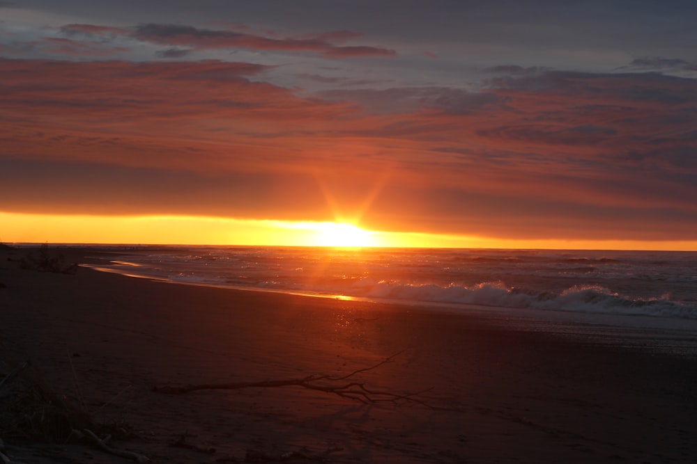 sea waves crashing on shore during sunset