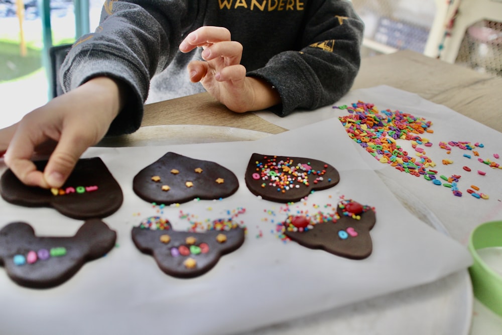 person holding brown and white heart shaped cookies
