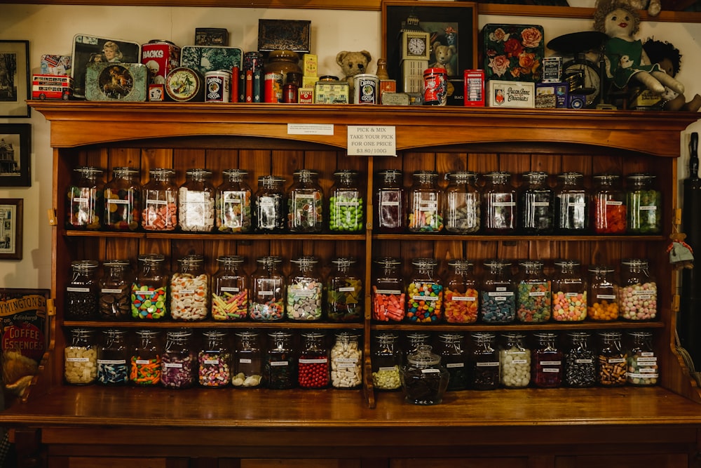 assorted food in clear glass containers on brown wooden shelf