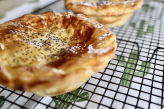 Golden, crispy savory pastries cooling on a wire rack in a country kitchen