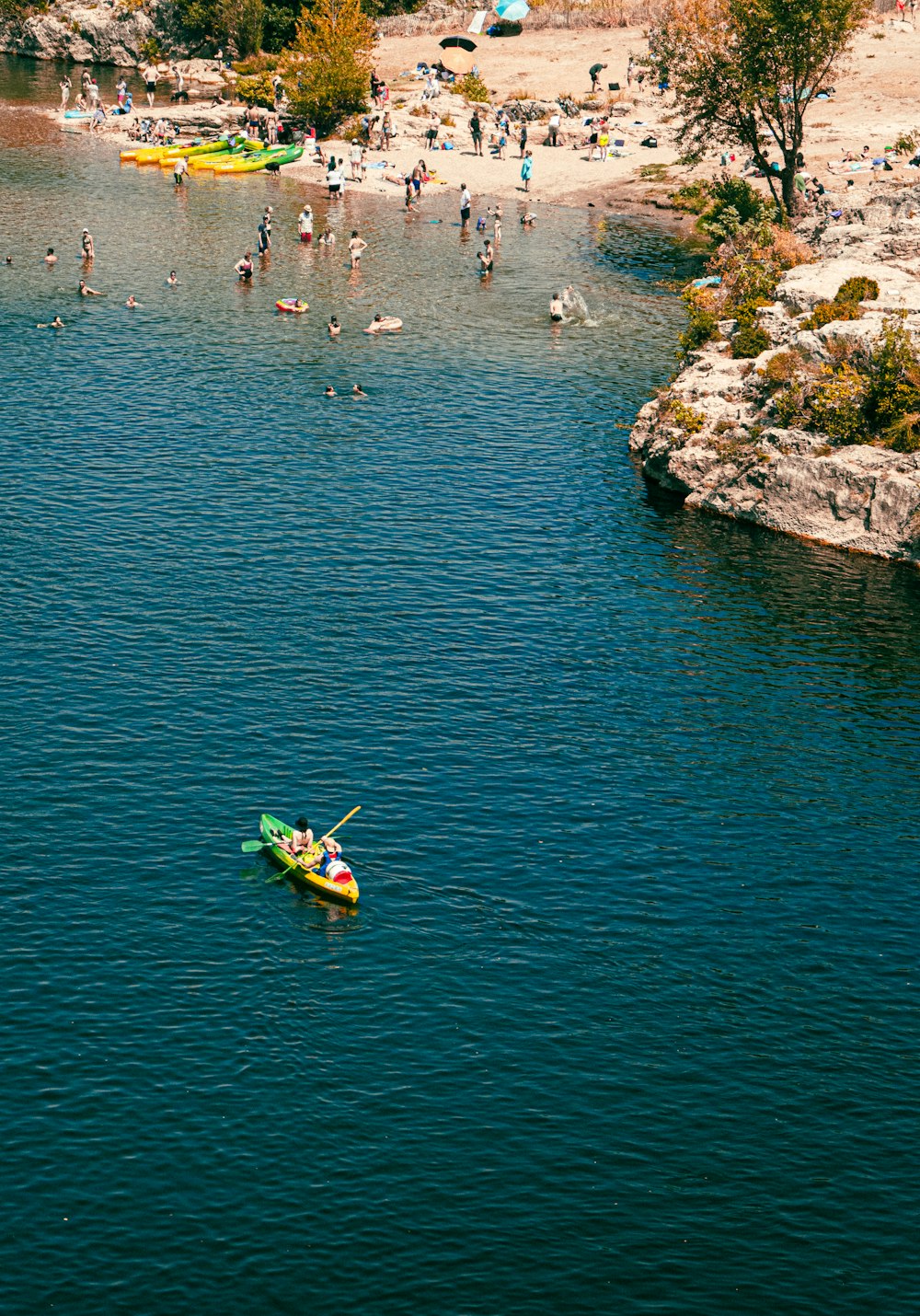 people riding on green kayak on blue sea during daytime