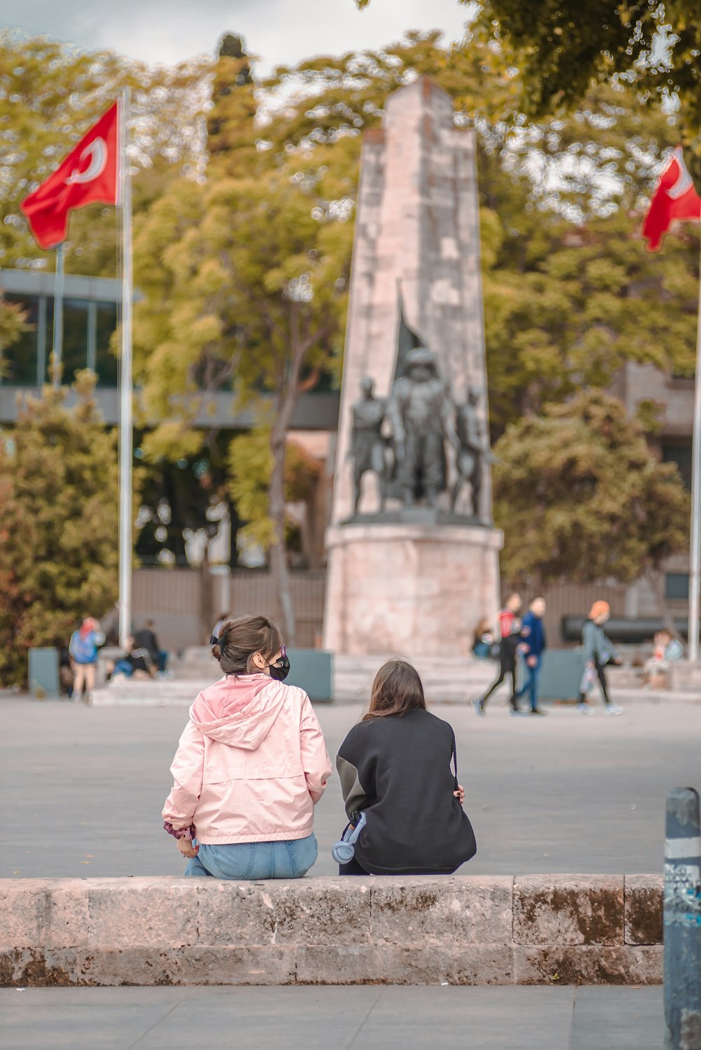 woman in pink jacket standing beside woman in black shirt