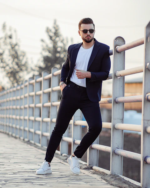 Homem em blazer preto apoiado no corrimão
