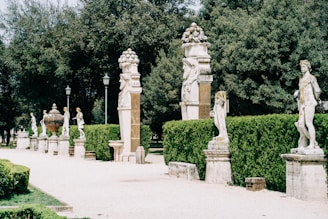brown concrete statue near green trees during daytime