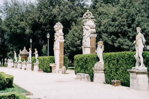 brown concrete statue near green trees during daytime