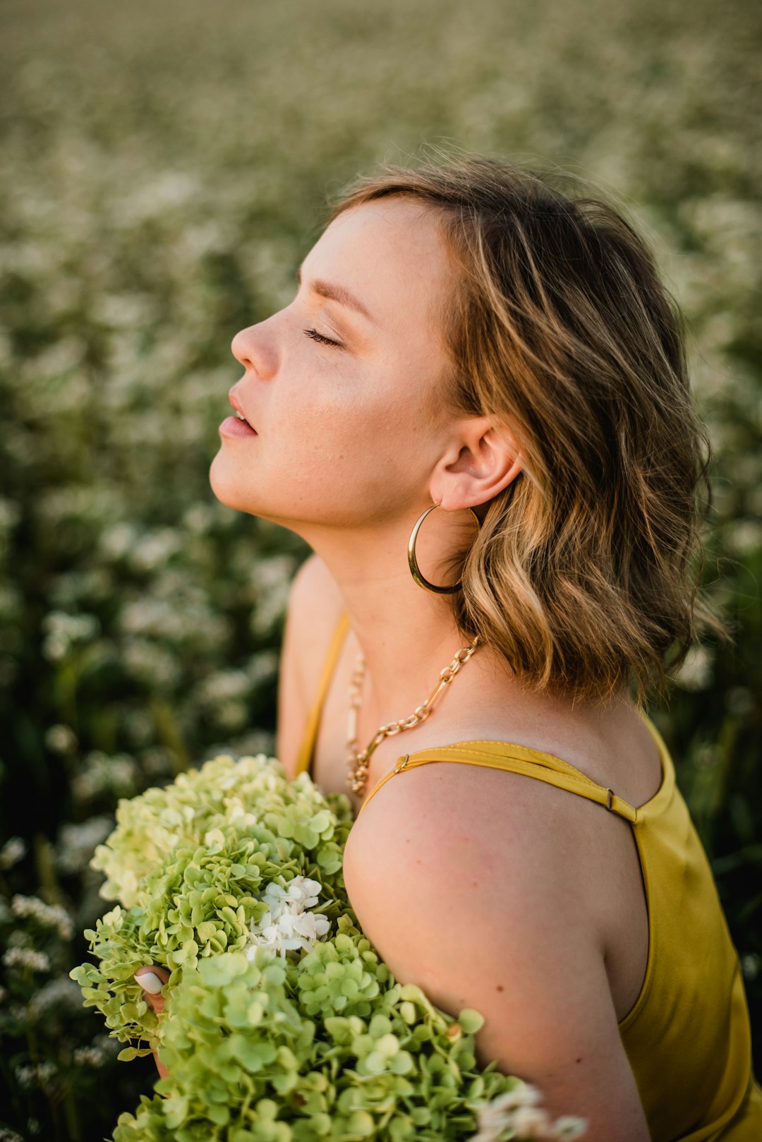 woman in yellow tank top holding white flower bouquet