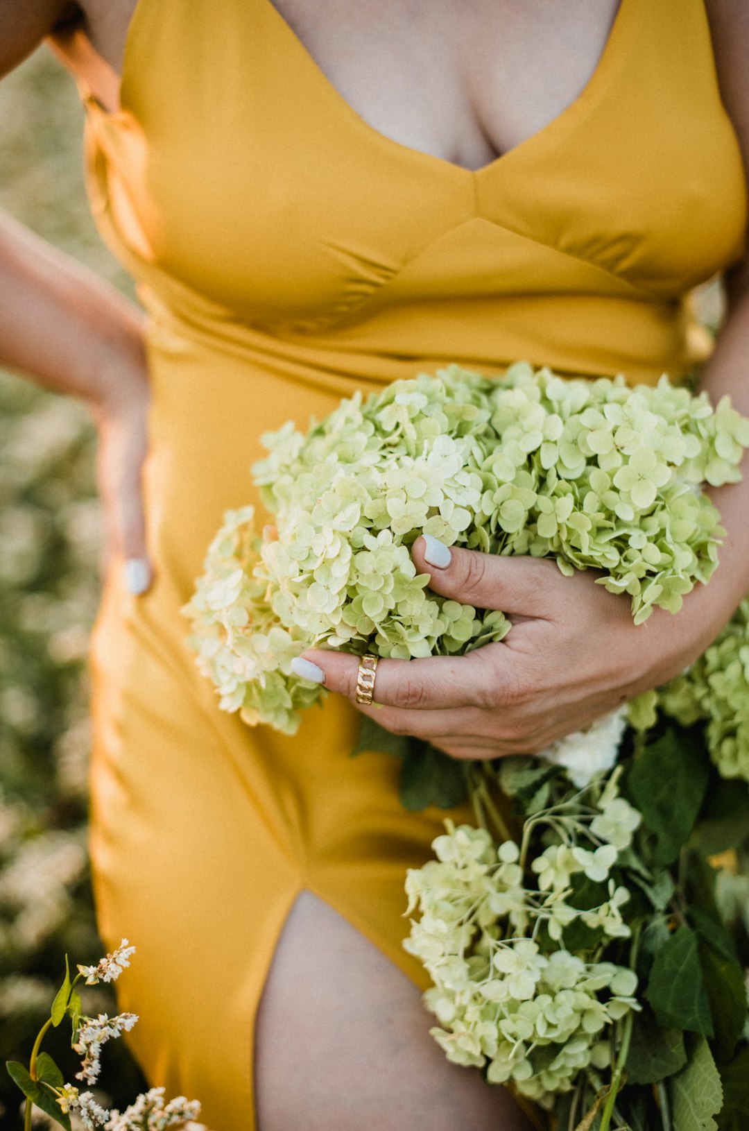 woman in yellow dress holding white flower bouquet