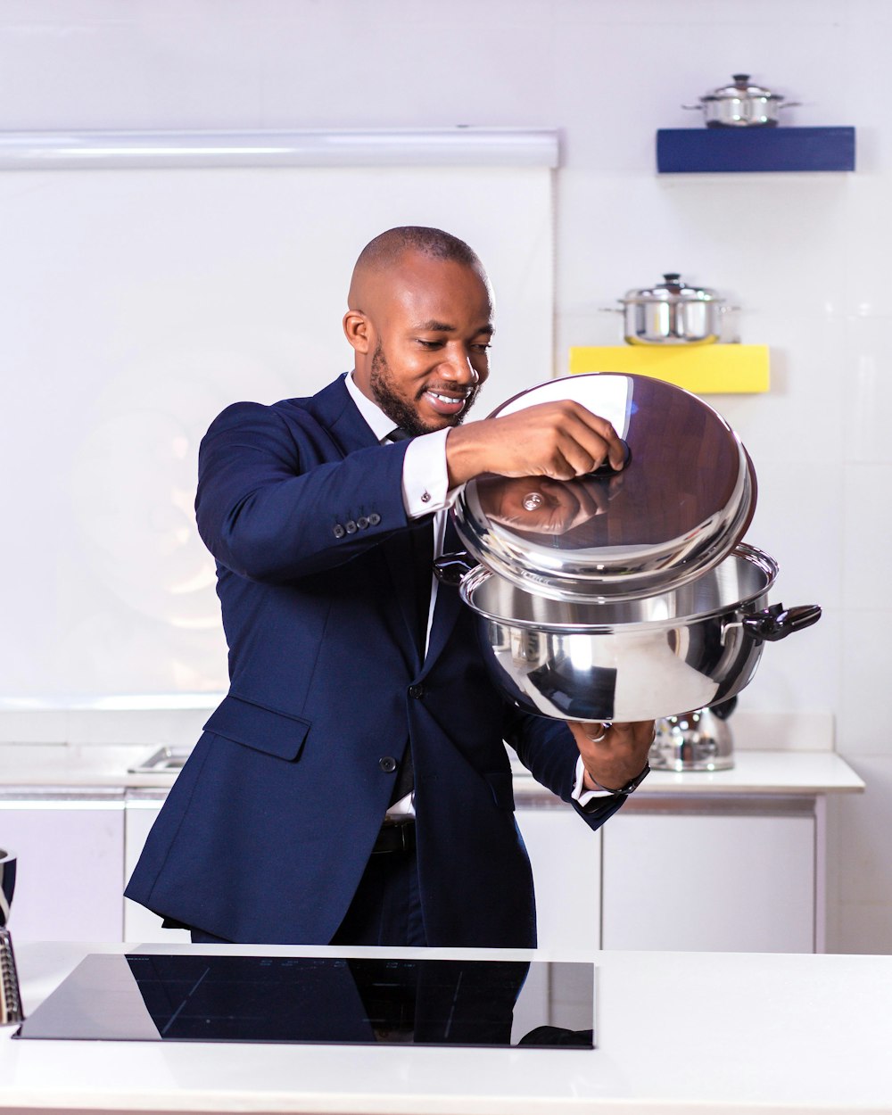 man in black suit holding stainless steel cooking pot