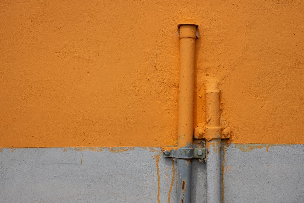 brown metal pipe on brown concrete wall