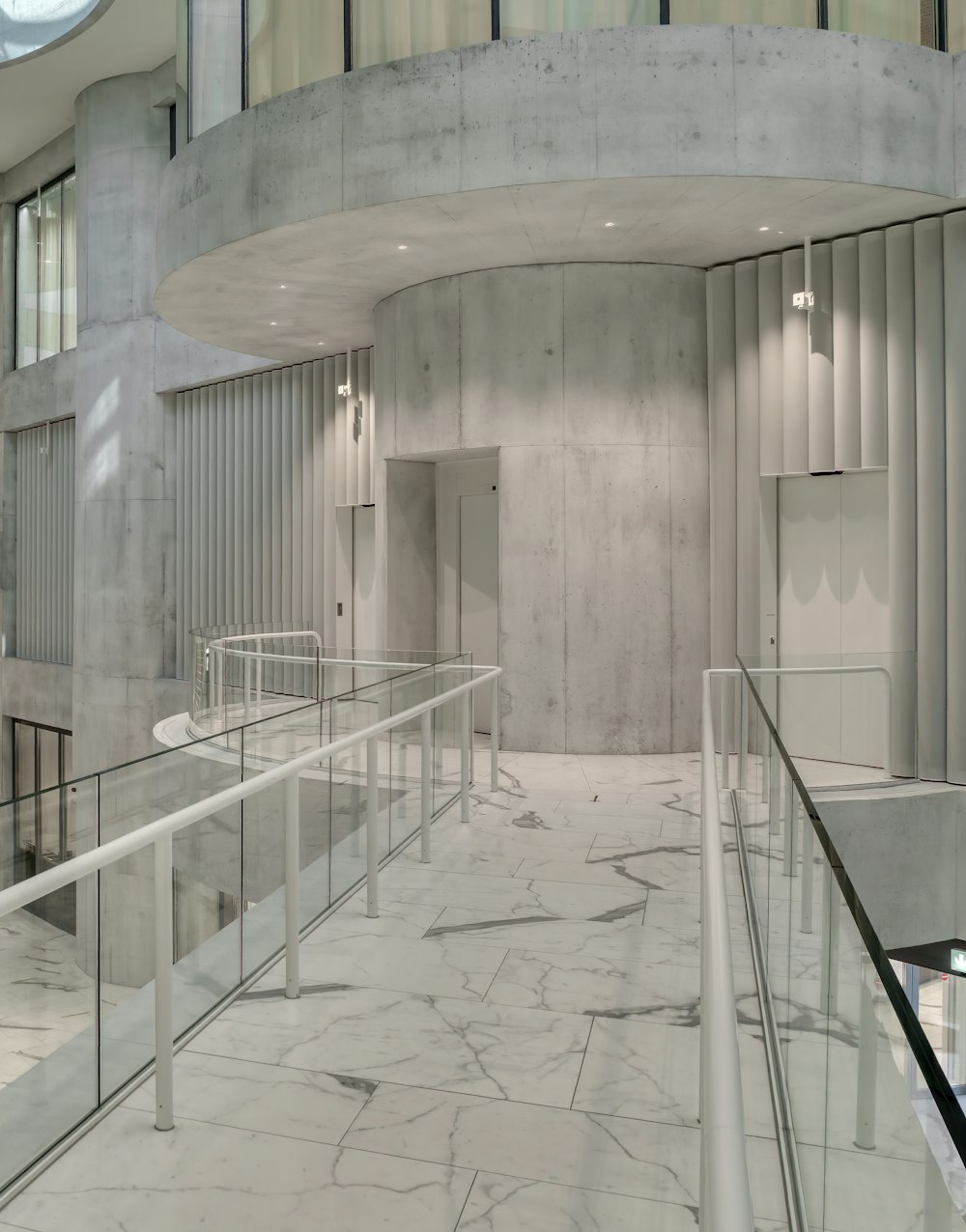 white concrete staircase with stainless steel railings