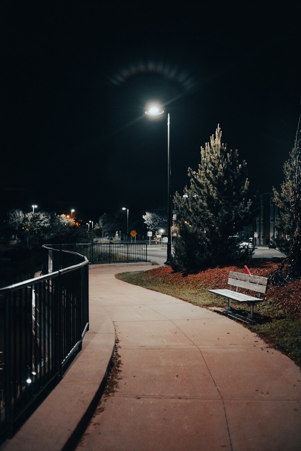 black metal fence near road during night time