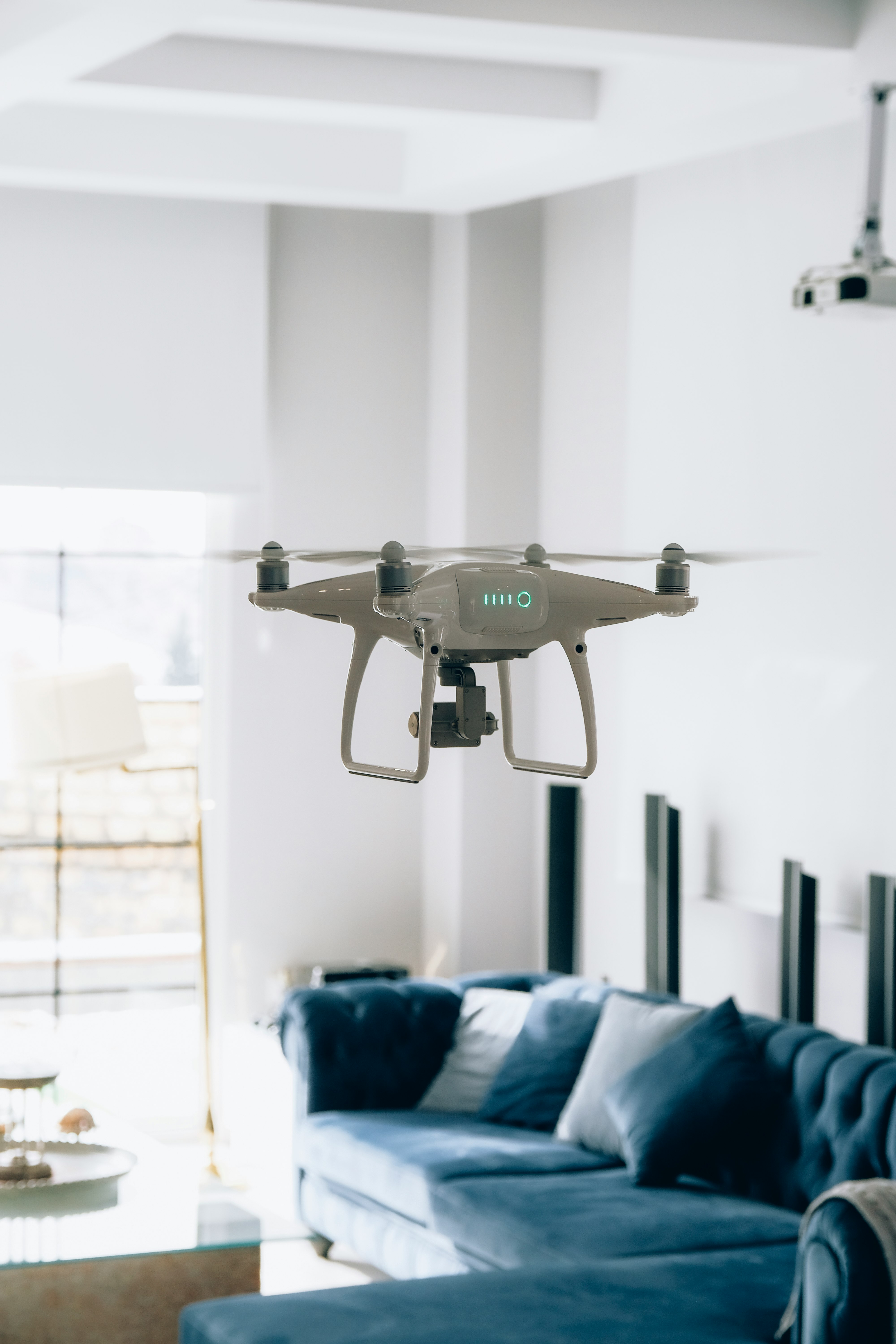 gray and black drone near blue plastic bucket