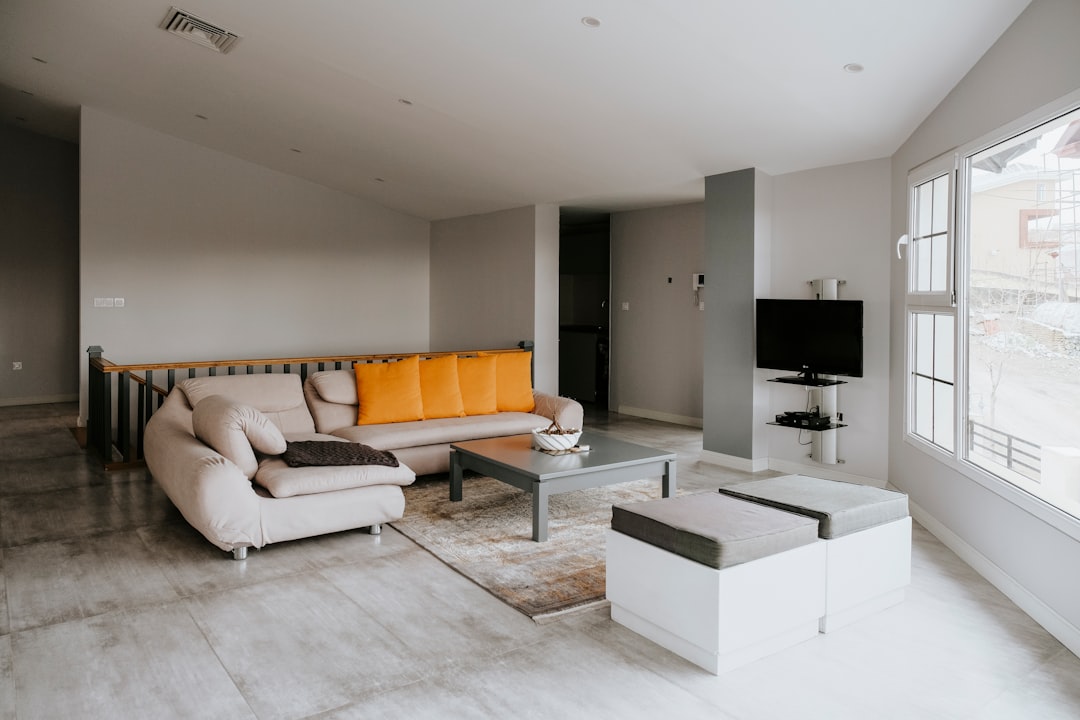 orange and white couch beside black flat screen tv