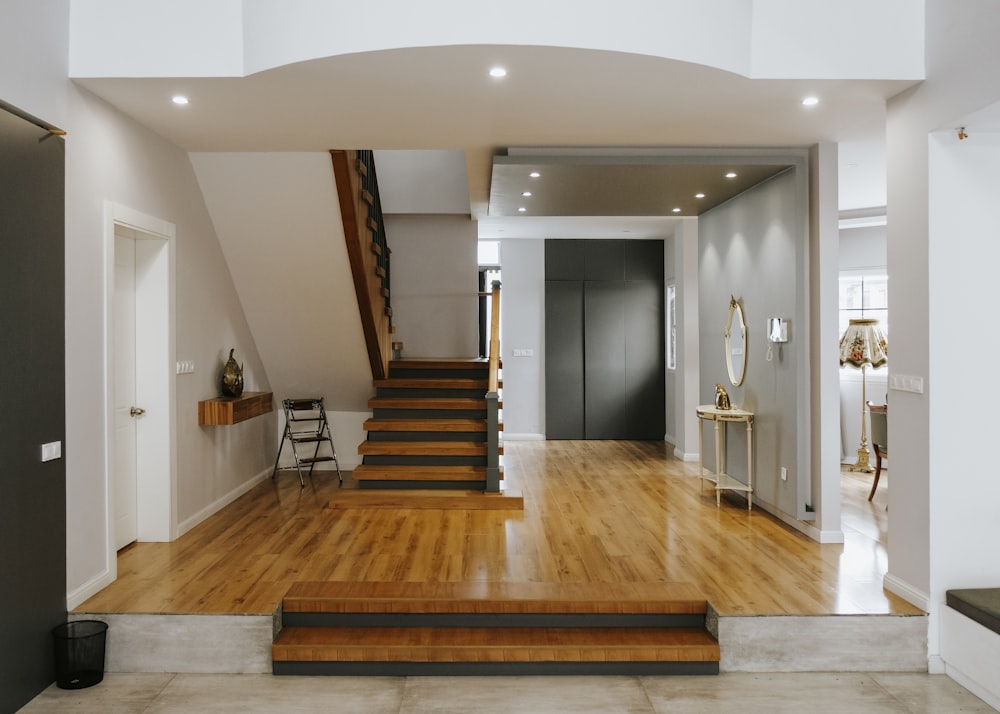 brown wooden staircase near white wooden door